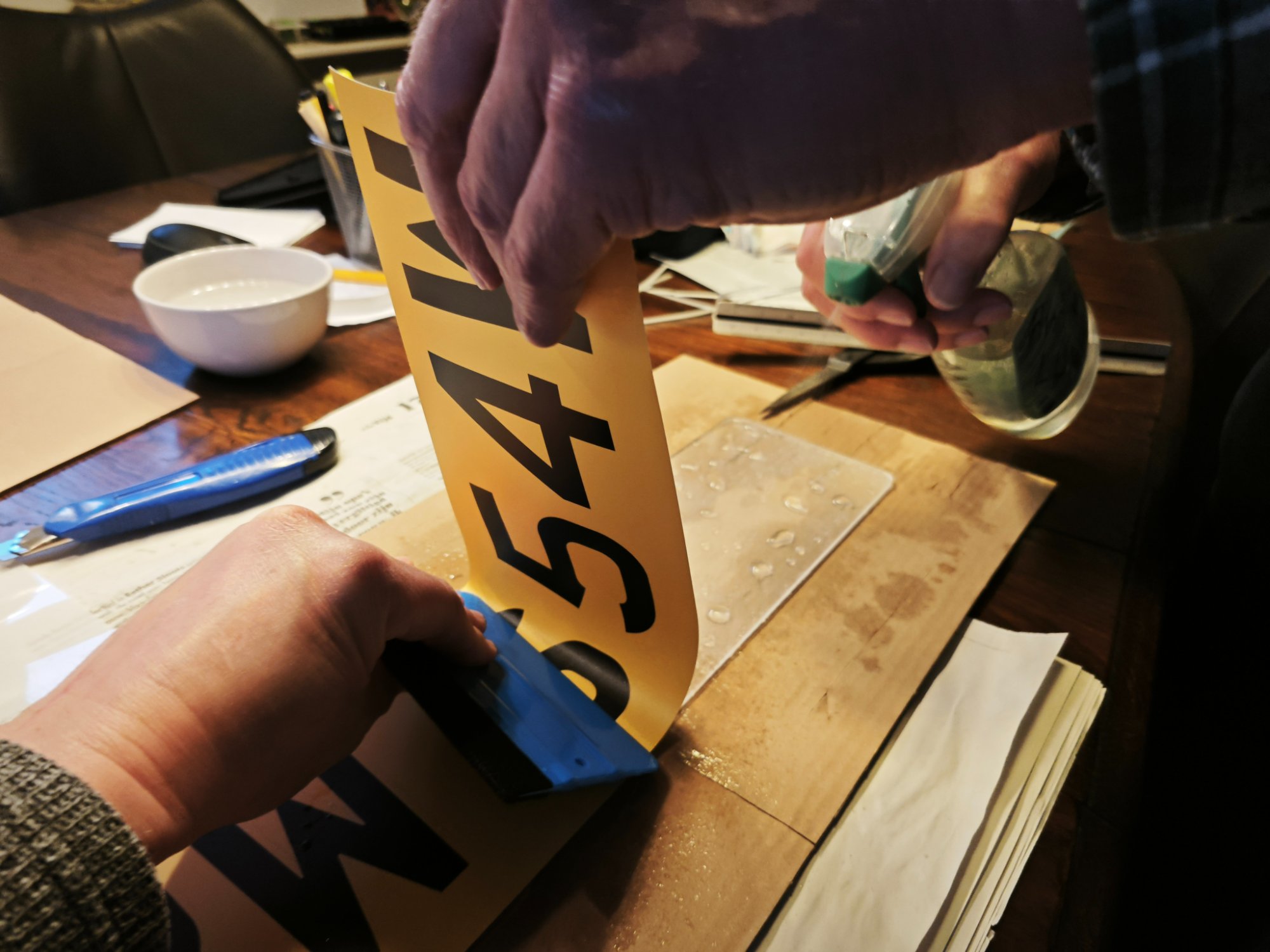 Het aanbrengen van de vinylsticker met een rakel